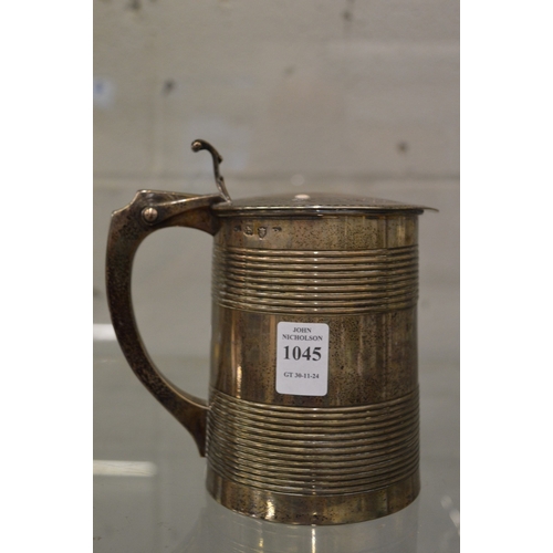 1045 - A Georgian silver lidded tankard with engraved hinged cover, the body with two pairs of contrentric ... 