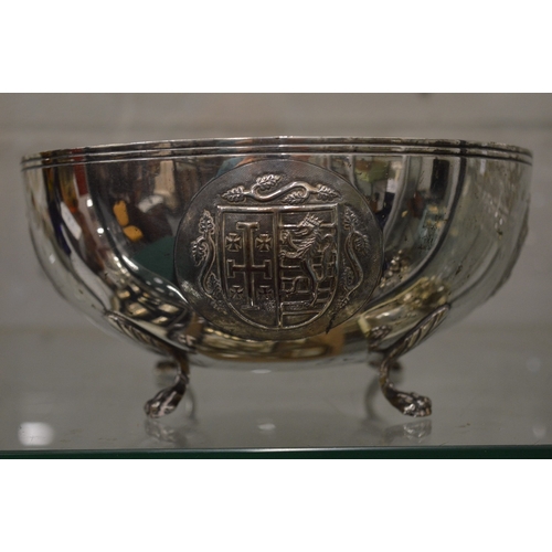 1046 - An unusual Continental silver circular bowl on four scroll feet, the body embossed with heraldic shi... 