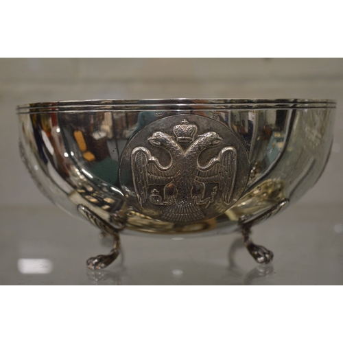 1046 - An unusual Continental silver circular bowl on four scroll feet, the body embossed with heraldic shi... 