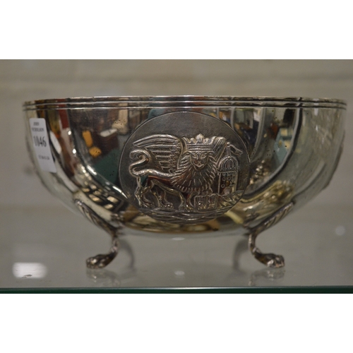 1046 - An unusual Continental silver circular bowl on four scroll feet, the body embossed with heraldic shi... 