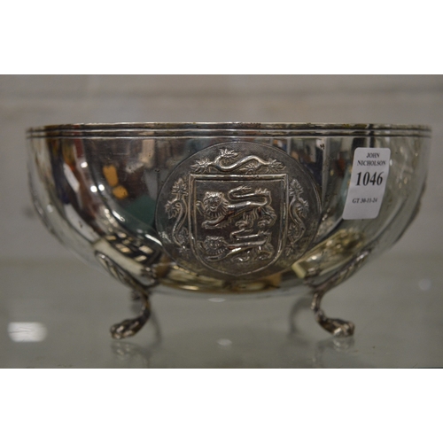 1046 - An unusual Continental silver circular bowl on four scroll feet, the body embossed with heraldic shi... 