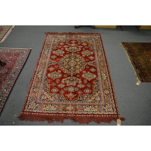 323 - A Persian style rug, red ground with floral decoration, 187cm x 118cm.