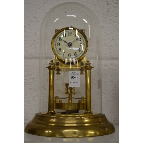 580 - A brass anniversary style clock under a glass dome.