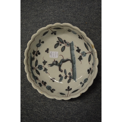 607 - An 18th century tin glazed bowl together with a tin glaze dish decorated with a bird (both with faul... 