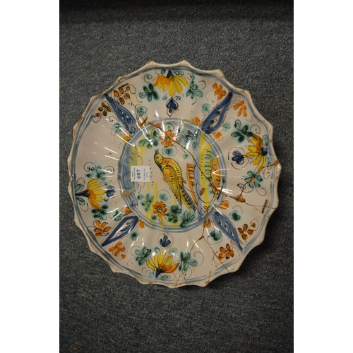 607 - An 18th century tin glazed bowl together with a tin glaze dish decorated with a bird (both with faul... 