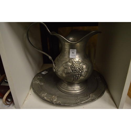 61 - A pewter jug and dish.