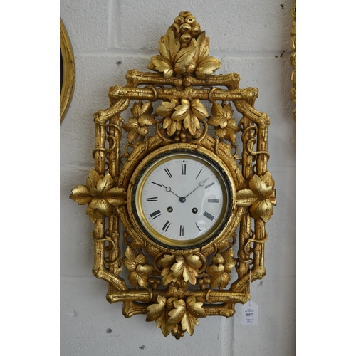 857 - An eight day circular wall clock housed within an ornate carved and gilded frame depicting fruit and... 