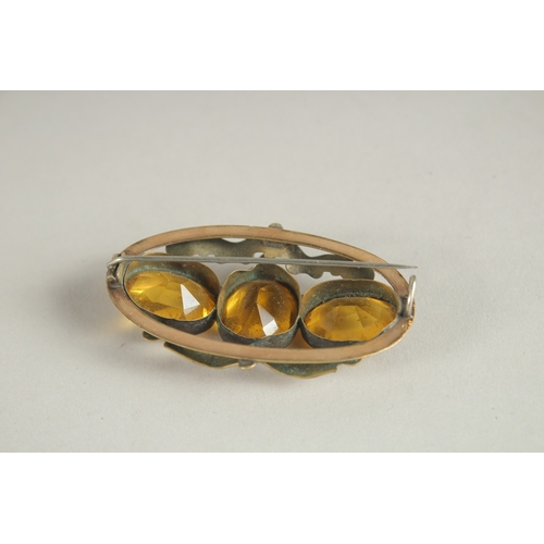 1005 - A DECORATIVE BROOCH, set with three citrine coloured stones. 6cms wide.