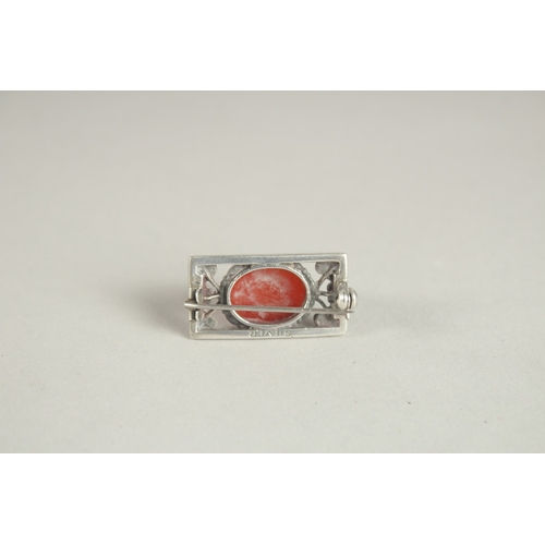 1006 - A SMALL SILVER AND CABOCHON BROOCH, in The Manner of Charles Horner. 3cms wide.