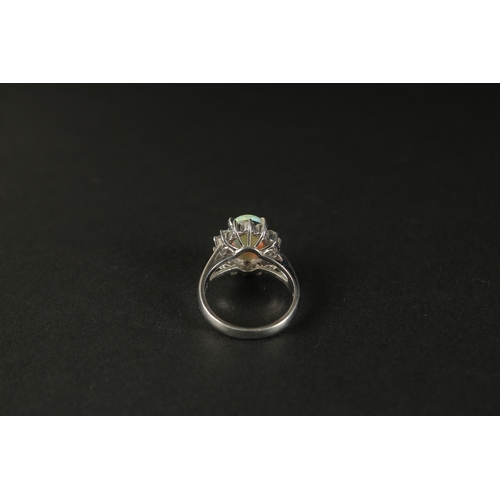 1011 - A PLATINUM RING set with a cabochon oval opal and a halo of RBC diamonds in a small ring size. Opal ... 