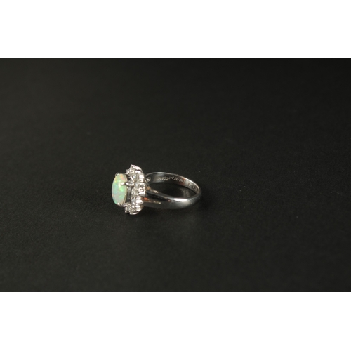 1011 - A PLATINUM RING set with a cabochon oval opal and a halo of RBC diamonds in a small ring size. Opal ... 