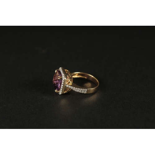 1036 - AN 18CT YELLOW GOLD RING set with a large checkerboard cushion-cut amethyst surrounded by RBC diamon... 