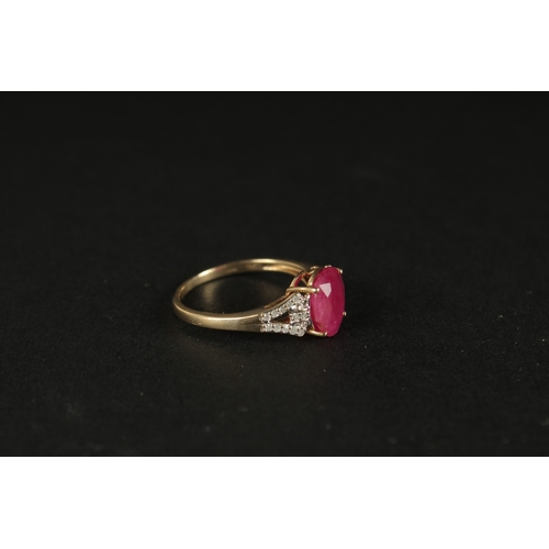 1039 - A 9CT YELLOW GOLD OVAL RUBY RING with diamonds set to the shoulders, boxed.