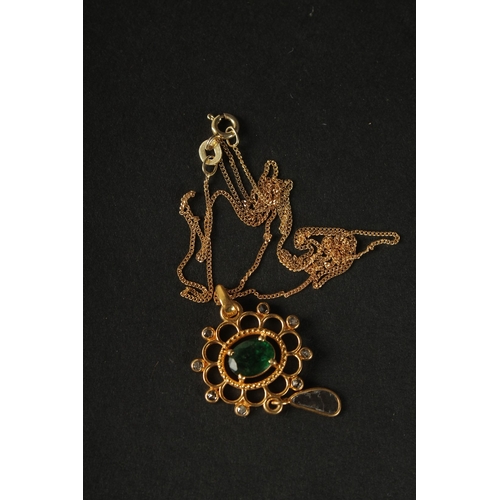 1047 - A FANCY PENDANT in yellow metal set with oval emerald, rose-cut diamonds and a suspended slice diamo... 