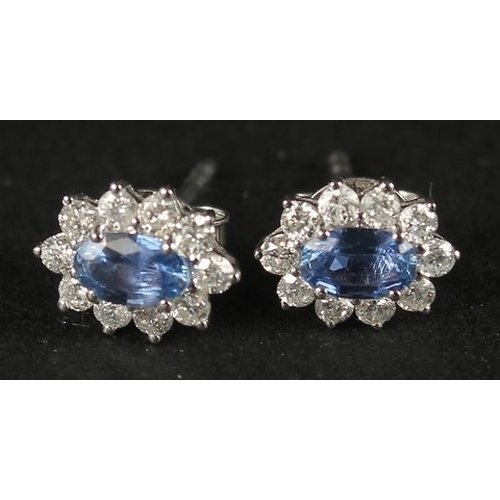 1053 - A PAIR OF 18CT WHITE GOLD OVAL SAPPHIRE AND RBC DIAMOND CLUSTER STUDS, boxed. Sapphires 0.66ct.  Dia... 