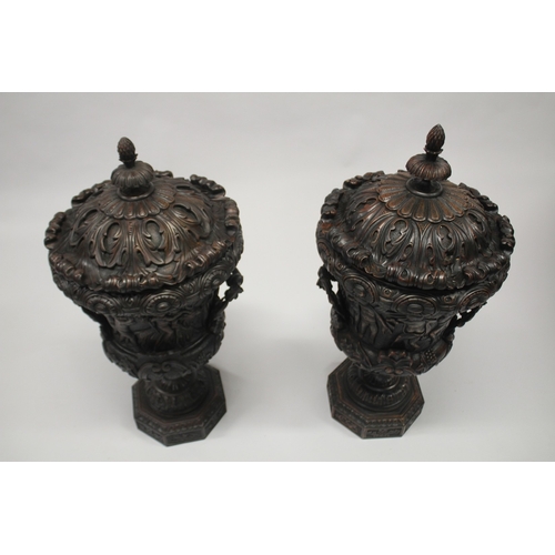 508 - A GOOD PAIR OF 18TH CENTURY IRISH DESIGN MAHOGANY TWO-HANDLED URNS AND COVERS, carved with cupids, s... 