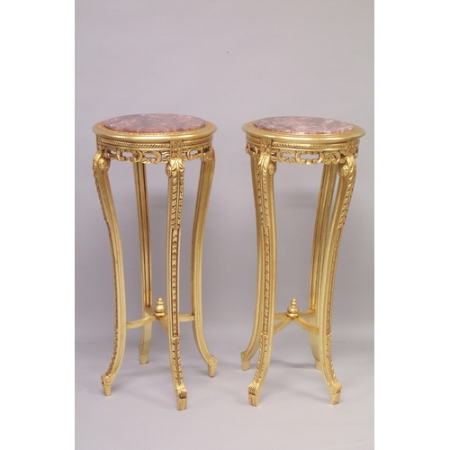 553 - A TALL PAIR OF GILTWOOD CIRCULAR MARBLE TOP STANDS on four curving legs. 44ins high x 18ins diameter... 