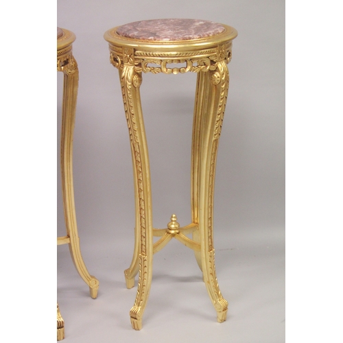 553 - A TALL PAIR OF GILTWOOD CIRCULAR MARBLE TOP STANDS on four curving legs. 44ins high x 18ins diameter... 