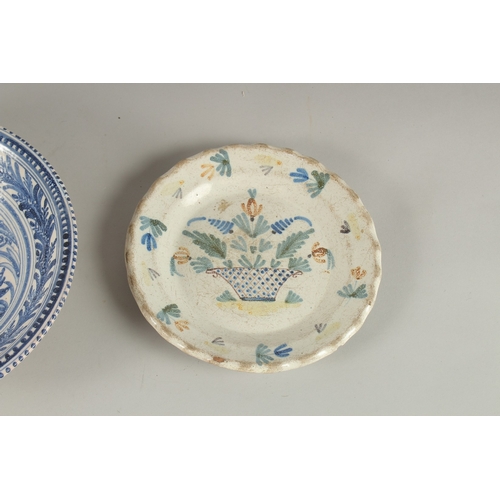 592 - A CONTINENTAL BLUE AND WHITE FAIENCE POTTERY BOWL, decorated with a bird, and a faience dish decorat... 