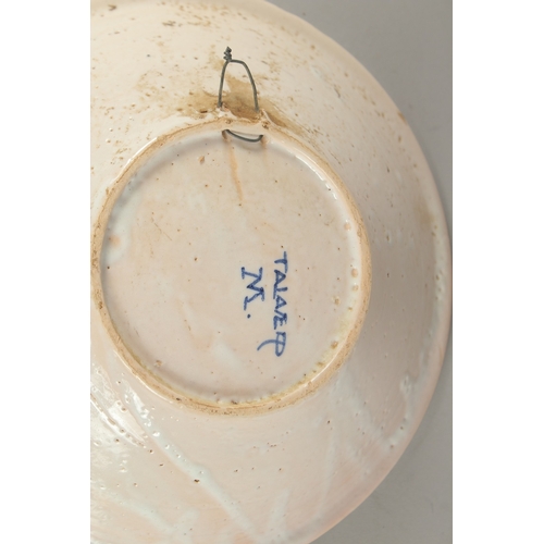 592 - A CONTINENTAL BLUE AND WHITE FAIENCE POTTERY BOWL, decorated with a bird, and a faience dish decorat... 