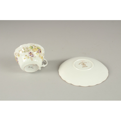 596 - AN AMUSING FLORAL CUP AND SAUCER, painted to the bottom of the cup 