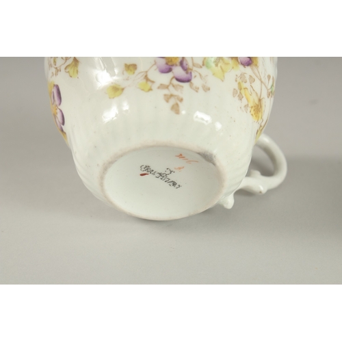 596 - AN AMUSING FLORAL CUP AND SAUCER, painted to the bottom of the cup 