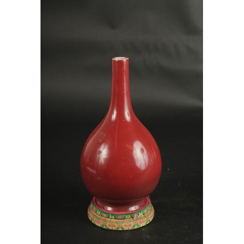 627 - A CHINESE COPPER RED PORCELAIN VASE with stand. Vase: 24cms high.