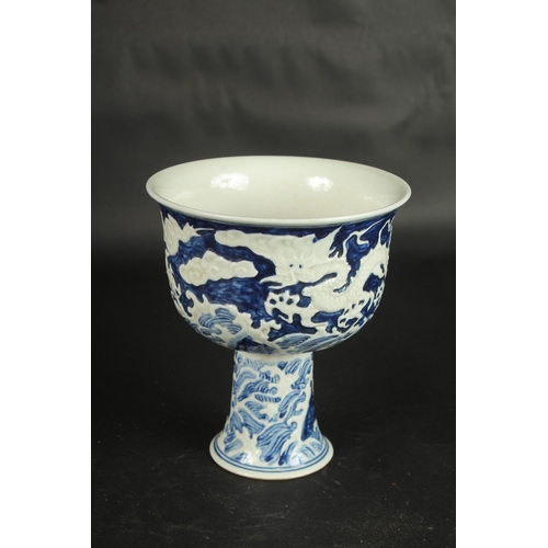 635 - A CHINESE BLUE AND WHITE CARVED DRAGON STEM CUP. 17.5cms high.