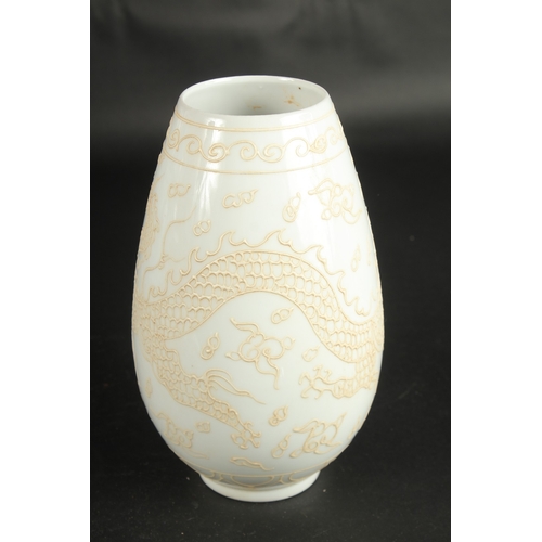 640 - A CHINESE PALE CELADON PORCELAIN DRAGON VASE. 23cms high.