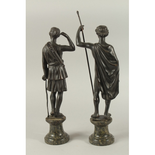 665 - GRAND TOUR BRONZES. A VERY GOOD PAIR OF CLASSICAL BRONZE FIGURES of a man carrying a staff and a you... 