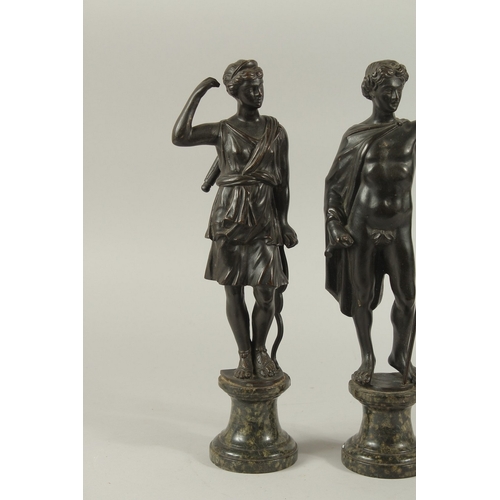 665 - GRAND TOUR BRONZES. A VERY GOOD PAIR OF CLASSICAL BRONZE FIGURES of a man carrying a staff and a you... 