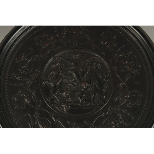 691 - A BOIS DURCI CIRCULAR PLAQUE, depicting classical female figures and putti. 30cms diameter.