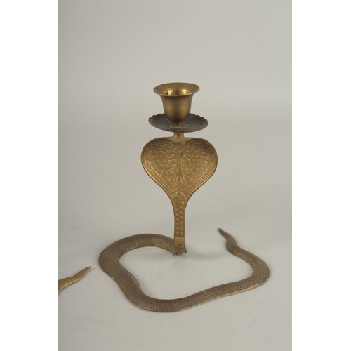 696 - A PAIR OF BRASS COBRA CANDLESTICKS. 17cms high.