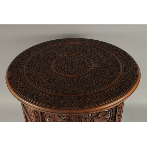 703 - A GOOD FOLDING INDIAN TABLE with circular top. 1ft 9ins diameter.