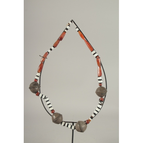 718 - A SILVER AND HARDSTONE TRIBAL NECKLACE on a stand.