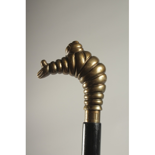 736 - A WOODEN WALKING STICK WITH A MICHELIN MAN HANDLE.