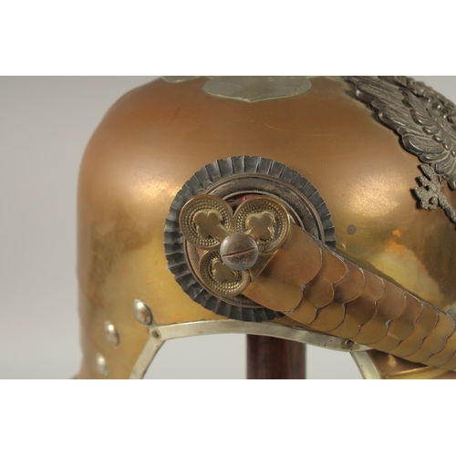 795 - A PRUSSIAN BRASS HELMET stamped JENOKERS, with large metal badge. Eagle F. R. 1813, with spike and c... 