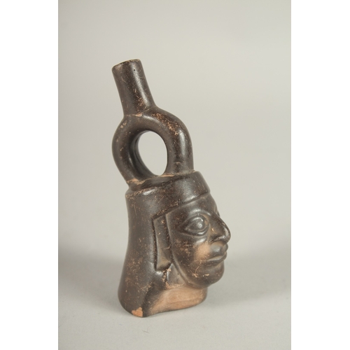 826 - A SMALL TERRACOTTA SOUTH AMERICAN FLASK in the form of a man's head. 9cms high.