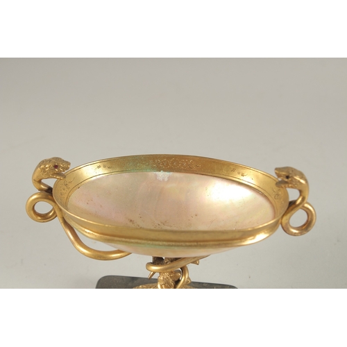 835 - A GRAND TOUR MOTHER-OF-PEARL and GILT METAL TWO HANDLED TAZZA, on a marble base with snake handles. ... 