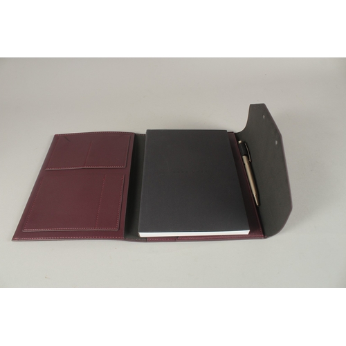 840 - A HUGO BOSS NOTEPAD AND PEN in a  burgundy case.