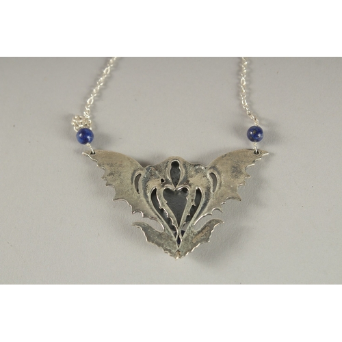 885 - AN ART NOUVEAU SILVER AND LAPIS PENDANT.