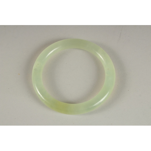 905 - A CELADON ICY JADE BANGLE.