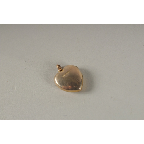 940 - A GOLD HEART SHAPED LOCKET.