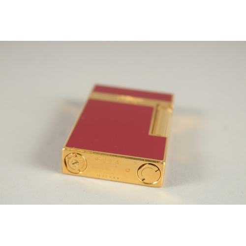 955 - A DUPONT RED ENAMEL AND GILT METAL CIGARETTE LIGHTER.