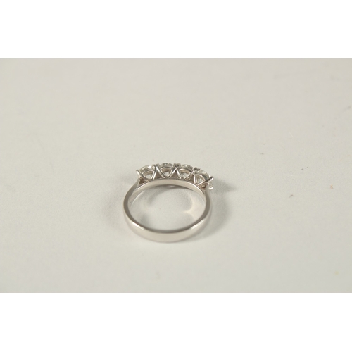 976 - A PLATINUM AND FOUR STONE DIAMOND RING.