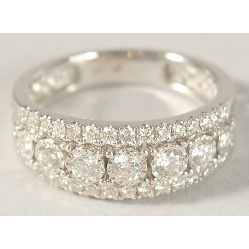 981 - AN 18CT WHITE GOLD AND DIAMOND HALF HOOP RING.