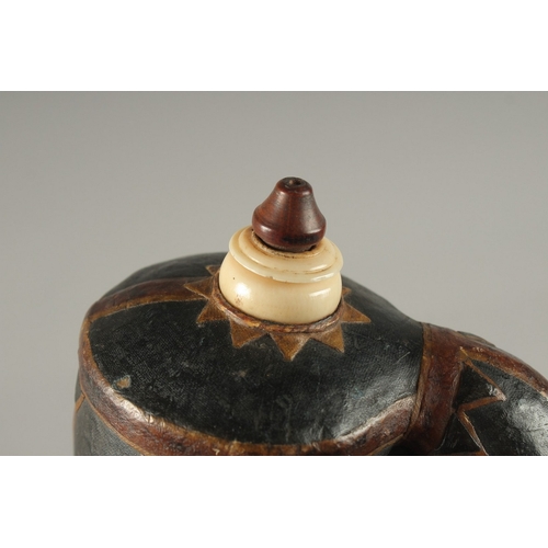 140 - A FINE 18TH-19TH CENTURY MUGHAL INDIAN LEATHER MOUNTED POWDER FLASK, 16cm high.