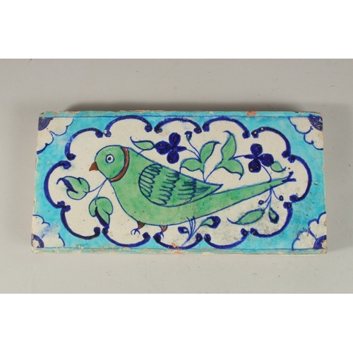 161 - A RARE EARLY 19TH CENTURY NORTH INDIAN MULTAN POTTERY TILE, depicting a green parrot, 30cm x 15cm.