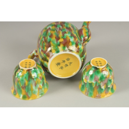 19 - A CHINESE YELLOW GREEN AND BROWN GLAZED PORCELAIN TEAPOT WITH TWO TEACUPS, each with character mark ... 