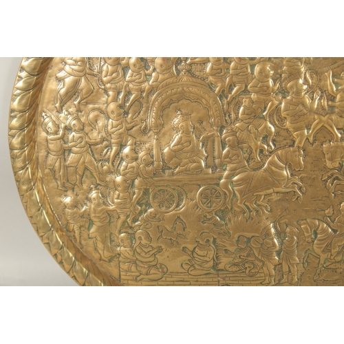 190 - A LARGE 19TH CENTURY NORTH INDIAN EMBOSSED BRASS TRAY, depicting a battle scene from the Ramayana wi... 